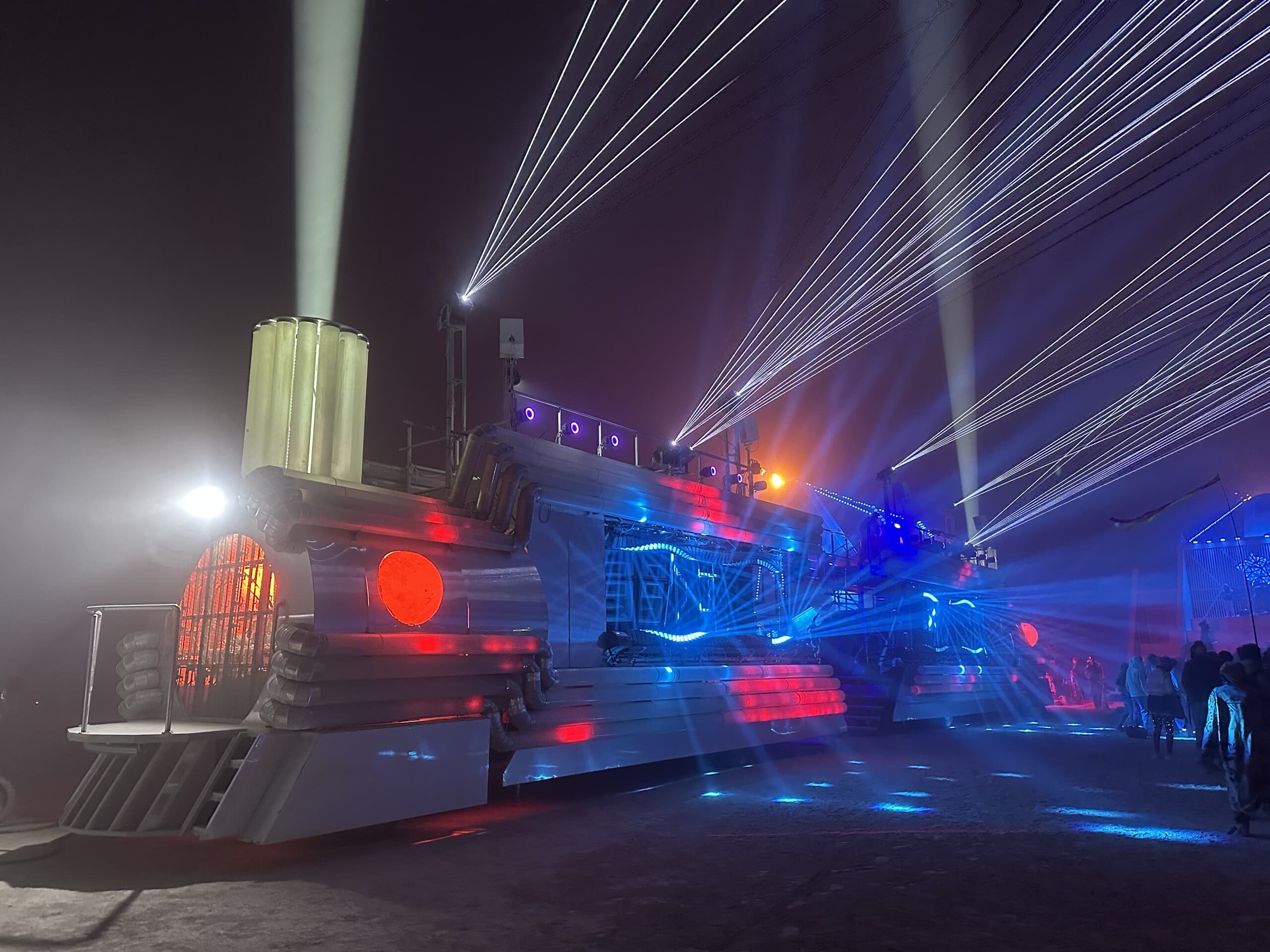 BiPolar Express in its full night configuration — lasers, searchlights and the illuminated train body on the Playa